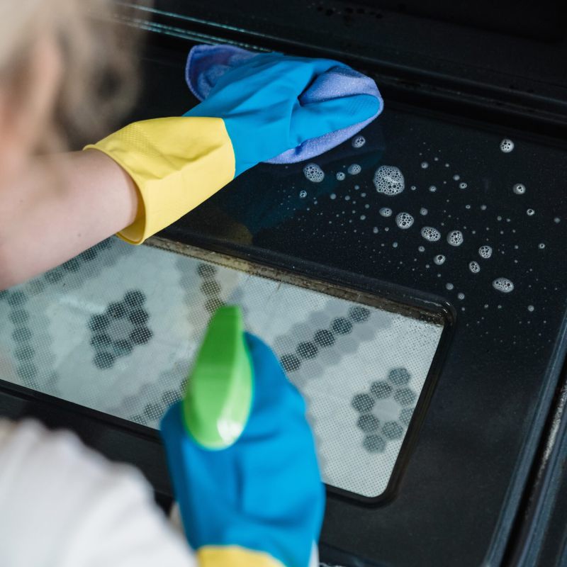 Techniker reinigt mit Wasserspray eine Klimaanlage.