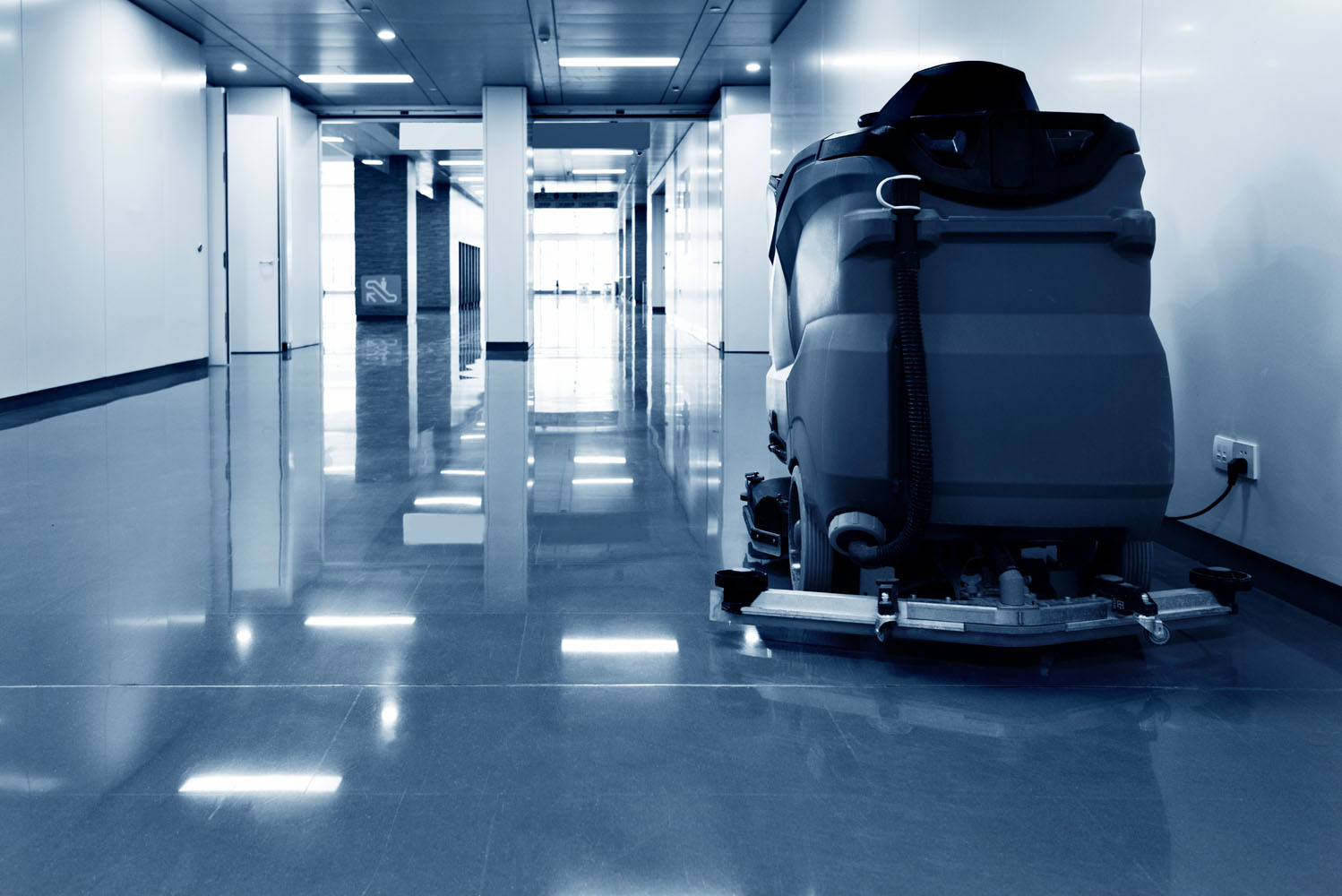 Reinigungsmaschine steht in einem Flur mit poliertem Boden.